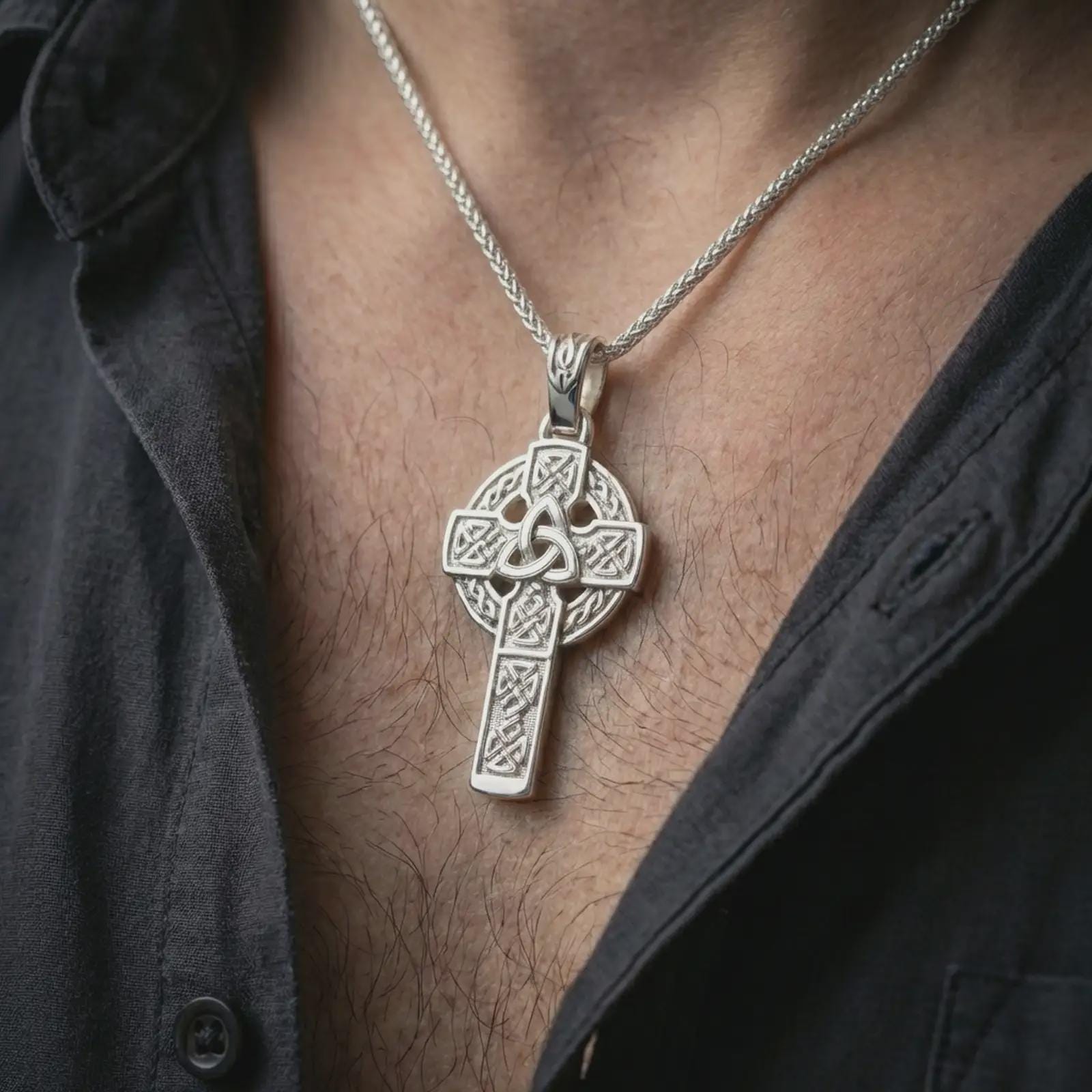 Polished silver Celtic cross pendant necklace worn on the neck, shown against the chest in a clean and elegant everyday wear composition.