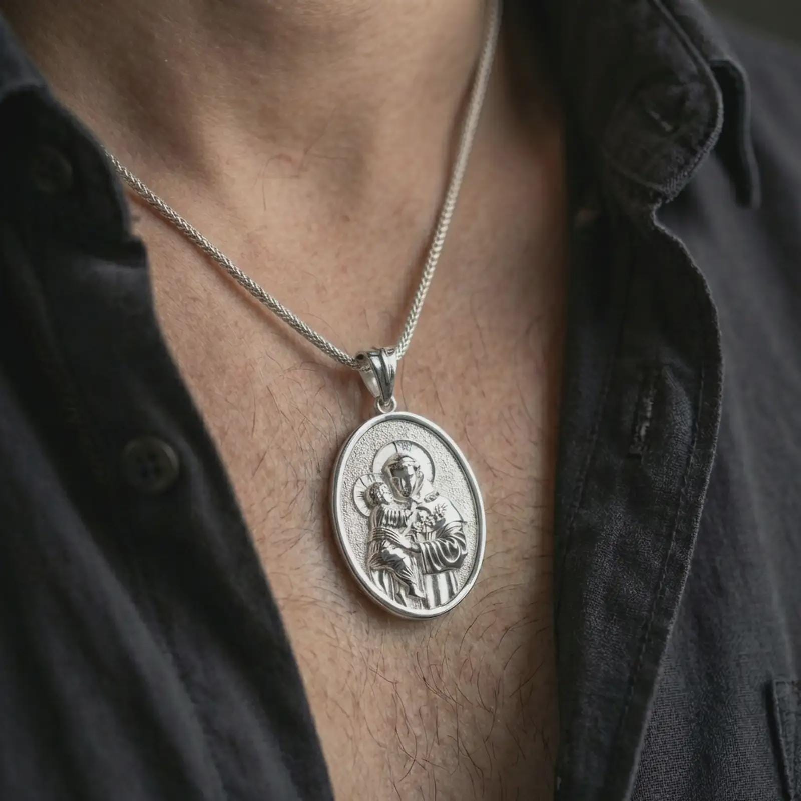 Polished silver Saint Anthony pendant necklace worn on the neck, shown against the chest in a clean and elegant everyday wear composition.