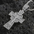 Load image into Gallery viewer, Polished silver Orthodox cross pendant necklace displayed on black volcanic rock, shown in a refined macro product shot with detailed crucifix figure and sacred engraved iconography.
