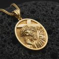Load image into Gallery viewer, Gold plated Jesus carrying cross pendant necklace presented on porous volcanic rock, highlighting the oval medallion form and devotional design in a luxurious close-up jewelry image.
