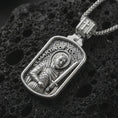 Load image into Gallery viewer, Polished silver Saint Martin of Tours pendant necklace displayed on black volcanic rock, shown in a refined macro product shot with detailed saint figure, sword, and engraved lettering.
