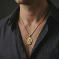 Load image into Gallery viewer, Gold plated Jesus Christ pendant necklace worn on the neck, captured on a human model in a premium dark-toned lifestyle frame.
