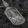 Load image into Gallery viewer, Sterling silver Saint Patrick dog tag pendant necklace with an oxidized finish resting on textured volcanic rock, captured in a close-up premium studio composition.
