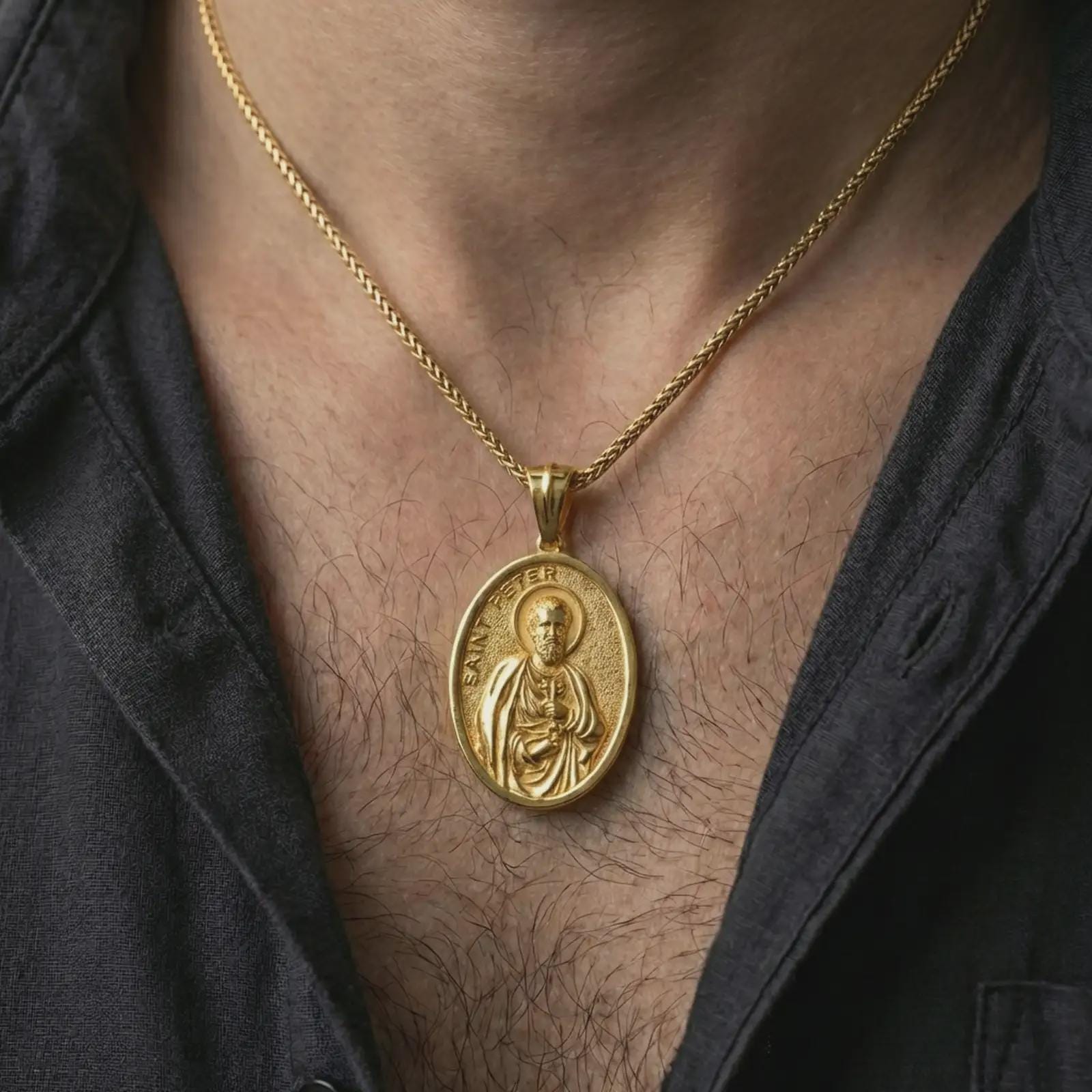 Gold plated Saint Peter pendant necklace worn on the neck, captured on a human model in a premium dark-toned lifestyle frame.