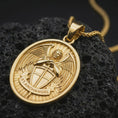 Load image into Gallery viewer, Gold plated Saint Michael Archangel pendant necklace presented on porous volcanic rock, highlighting the oval medallion form and sacred protective design in a luxurious close-up jewelry image.
