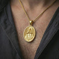 Load image into Gallery viewer, Gold plated Saint Michael Archangel pendant necklace worn on the neck, captured on a human model in a premium dark-toned lifestyle frame.
