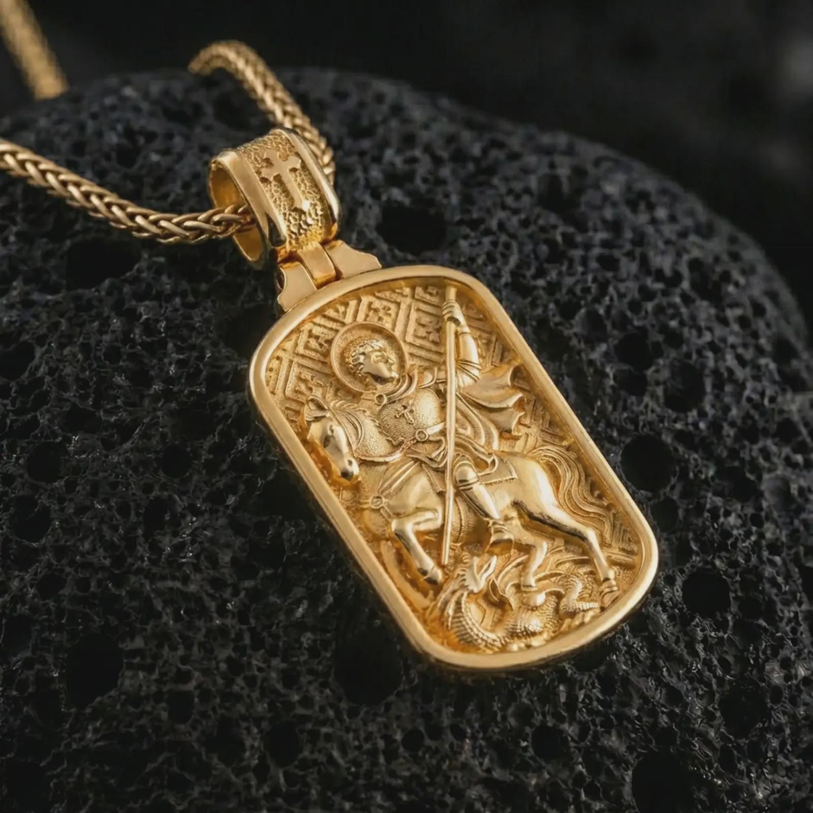 Gold plated Saint George dog tag pendant necklace presented on porous volcanic rock, highlighting the rectangular devotional form in a luxurious close-up jewelry image.
