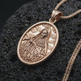 Load image into Gallery viewer, Rose gold plated Saint Rita pendant necklace on dark volcanic rock, photographed in a detailed premium studio macro view.
