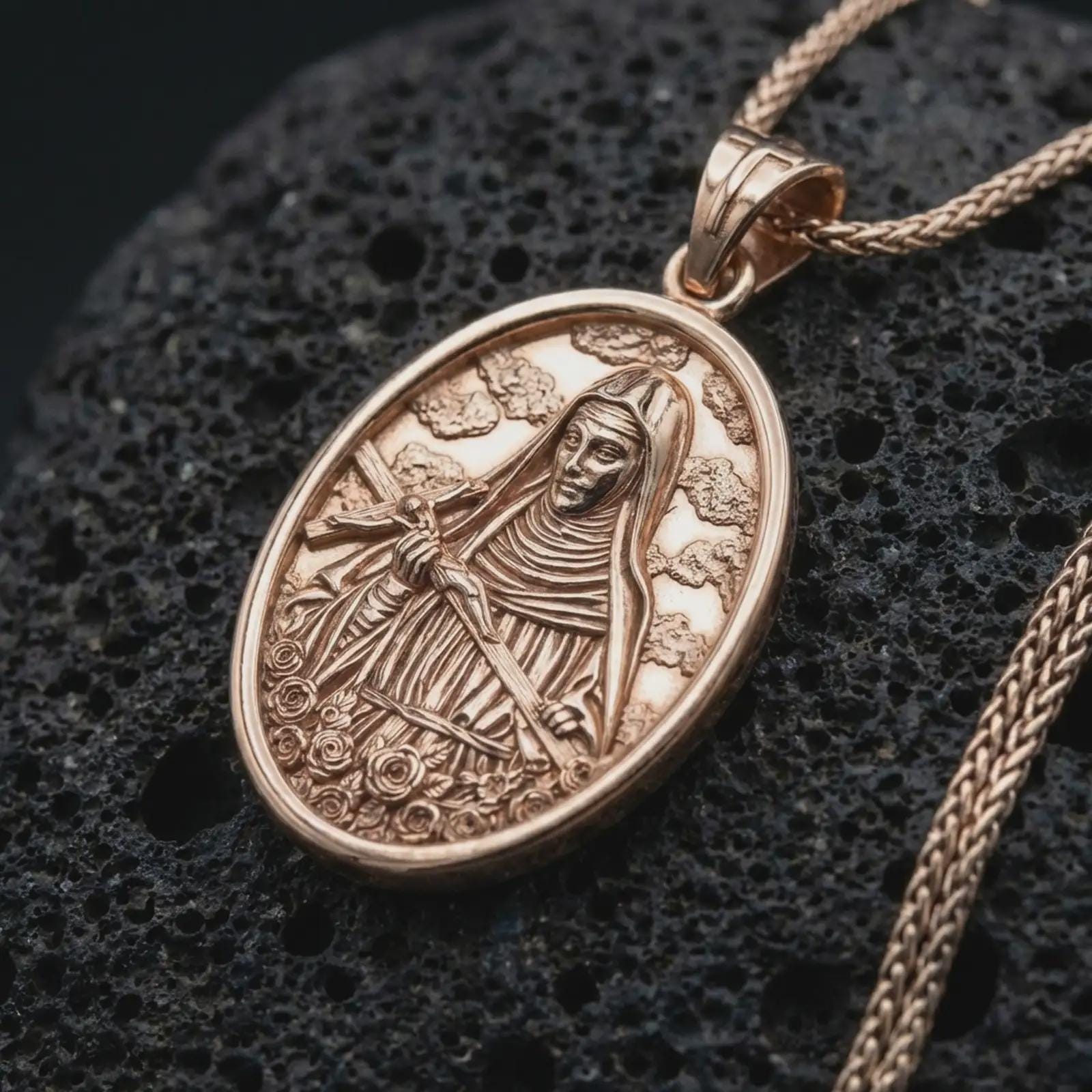 Rose gold plated Saint Rita pendant necklace on dark volcanic rock, photographed in a detailed premium studio macro view.