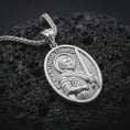 Load image into Gallery viewer, Polished silver Saint Martin of Tours pendant necklace displayed on black volcanic rock, shown in a refined macro product shot with detailed saint figure, sword, and engraved lettering.
