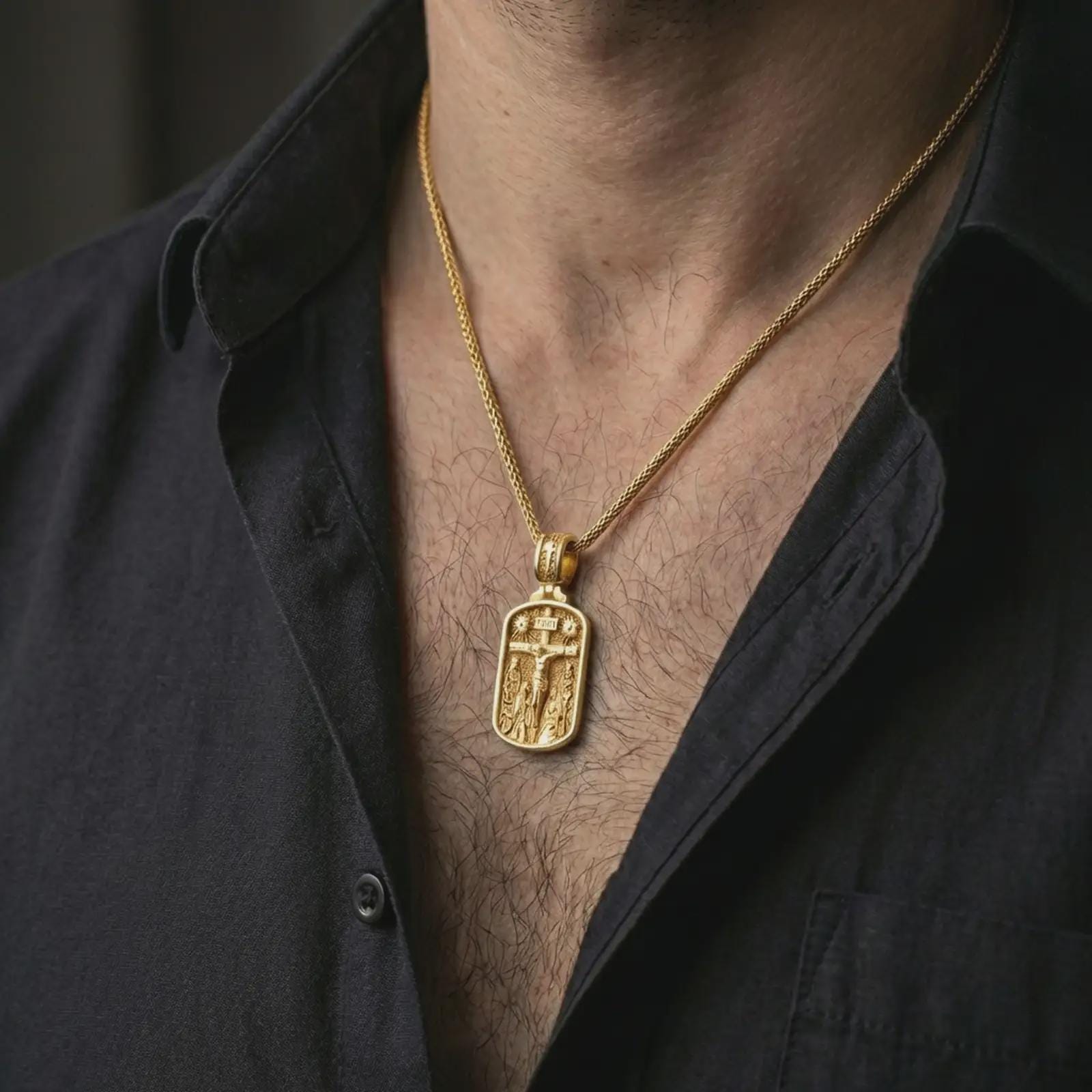 Gold plated Jesus INRI crucifixion pendant necklace worn on the neck, captured on a human model in a premium dark-toned lifestyle frame.