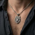 Load image into Gallery viewer, Oxidized deer pendant with floral antlers worn on the neck in a lifestyle jewelry shot, styled against the chest for a bold and nature-inspired statement look
