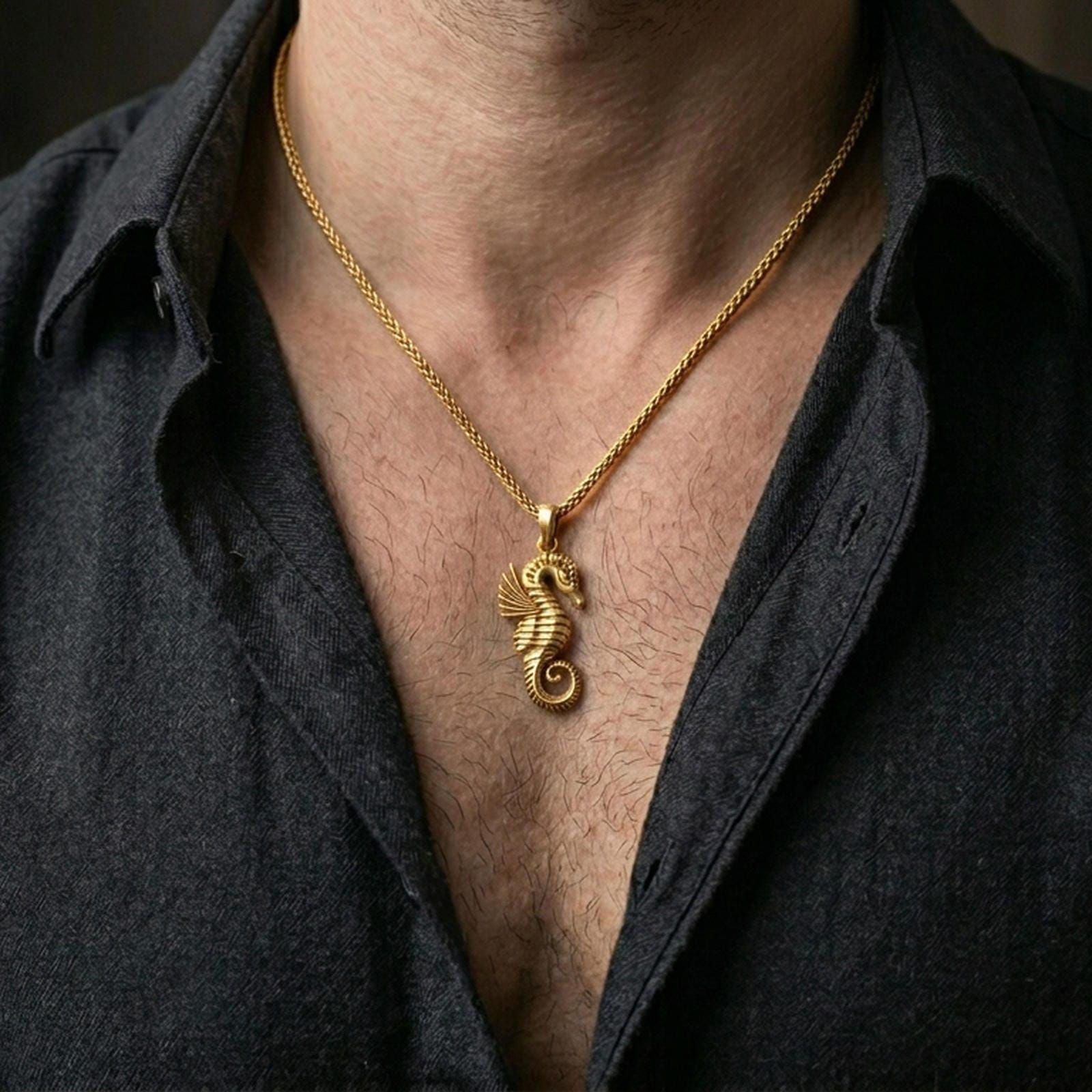 Gold plated seahorse pendant worn on the neck in a premium lifestyle composition with refined nautical jewelry styling