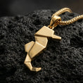 Load image into Gallery viewer, Gold plated origami seahorse pendant with geometric folded body, minimalist ocean-inspired design, and modern sculptural silhouette showcased on black volcanic rock in a refined macro jewelry image
