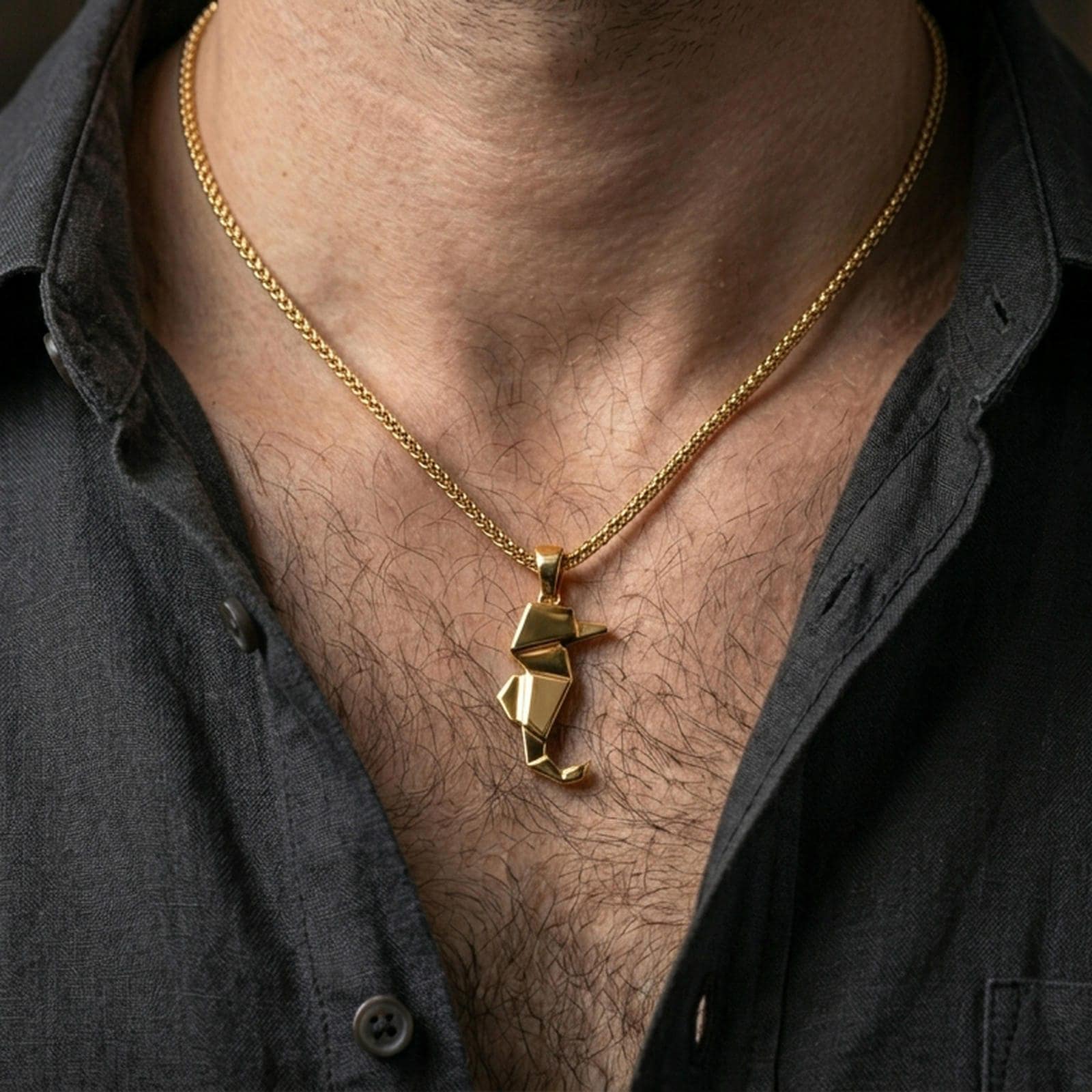 Gold plated origami seahorse pendant with sleek folded body and modern nautical styling worn on the neck in a premium lifestyle composition with refined contemporary jewelry styling