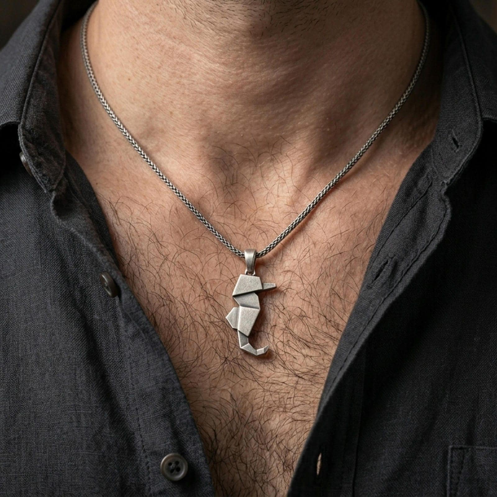 Oxidized origami seahorse pendant worn on the neck in a lifestyle jewelry shot, styled against the chest for a bold and modern ocean-inspired look