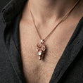 Load image into Gallery viewer, Rose gold plated deer pendant with realistic stag profile and dramatic antler detail worn on the neck in a refined lifestyle shot with a warm and elegant presentation
