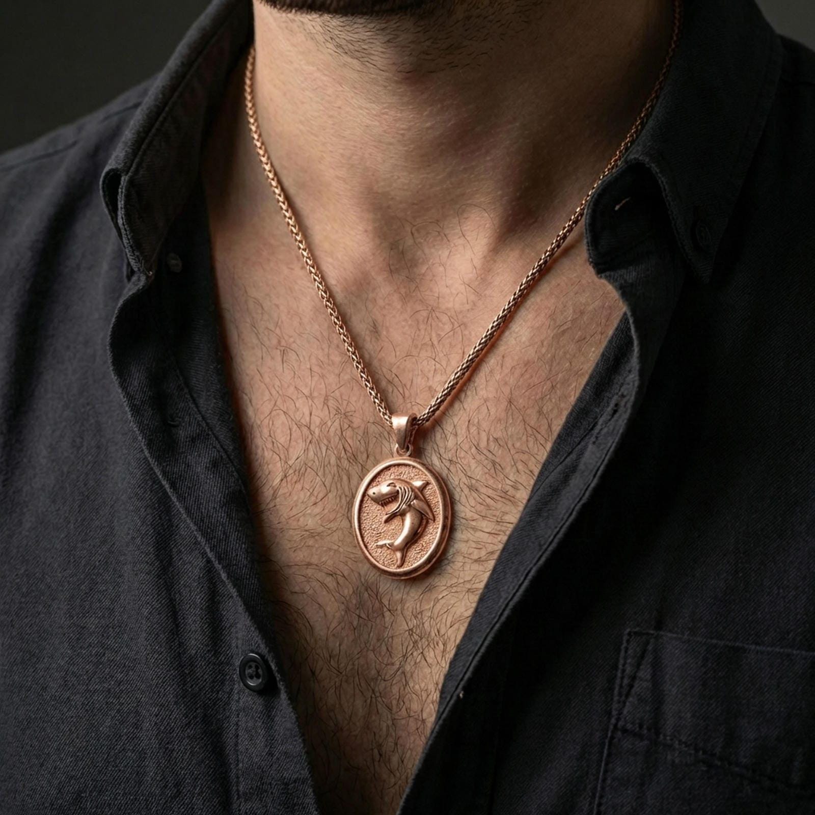 Rose gold plated shark necklace with sculpted shark figure and textured oval frame worn on the neck in a refined lifestyle shot with a warm and distinctive presentation