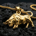 Load image into Gallery viewer, Gold plated bull pendant with powerful bovine form, realistic body structure, and striking zodiac-inspired design showcased on black volcanic rock in a refined macro jewelry image
