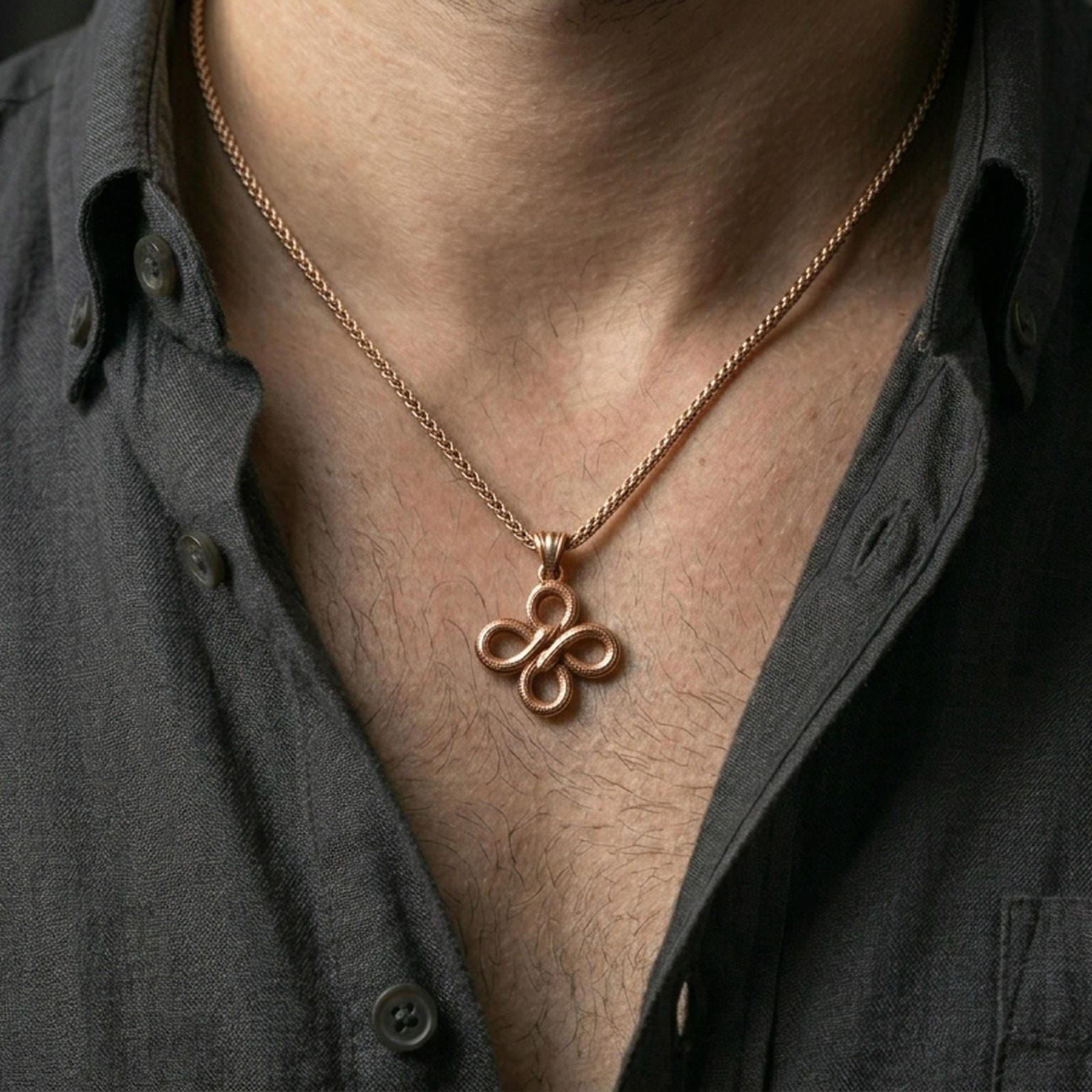 Rose gold plated serpent necklace with intertwined snake motif, detailed scale relief, and balanced knot design worn on the neck in a refined lifestyle shot with a warm and distinctive presentation