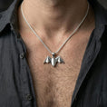 Load image into Gallery viewer, Polished silver bat necklace with geometric folded wing design worn on the neck in a close lifestyle frame, highlighting the sharp origami structure and nocturnal silhouette
