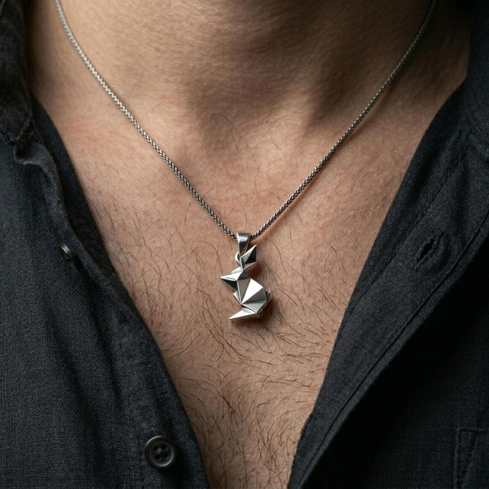 Polished silver bunny necklace with geometric folded form worn on the neck in a close lifestyle frame, highlighting the clean origami lines and modern animal silhouette