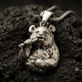 Load image into Gallery viewer, Bronze panda pendant with detailed fur texture, bamboo stalk accent, and playful animal silhouette displayed on dark volcanic rock in a close-up luxury jewelry composition
