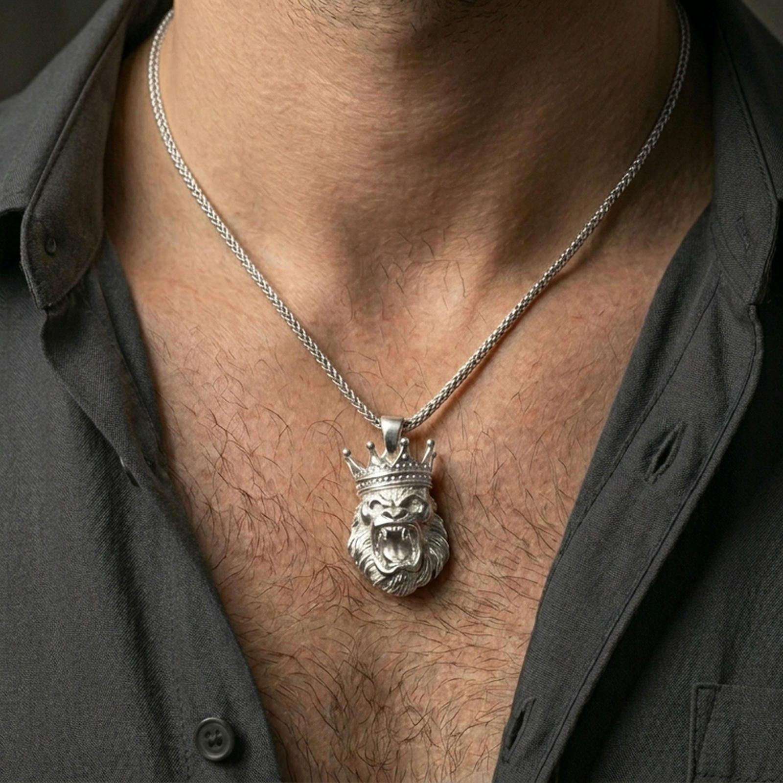 Polished silver crowned gorilla necklace with sculpted fur detail and fierce animal expression worn on the neck in a close lifestyle frame, highlighting the powerful primate motif