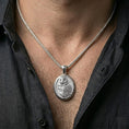 Load image into Gallery viewer, Polished silver owl necklace with oval medallion shape and detailed bird relief worn on the neck in a close lifestyle frame, highlighting the refined feather texture and elegant silhouette
