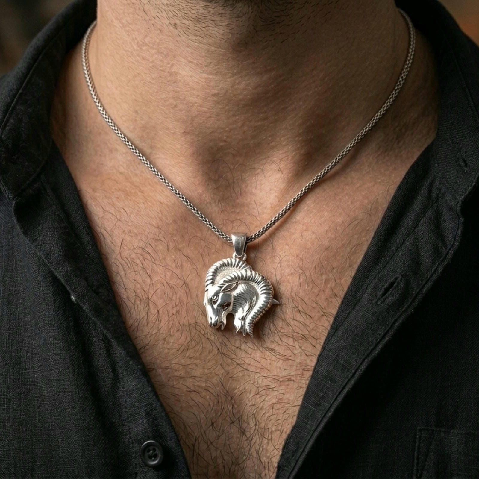 Polished silver ram necklace with detailed fur texture and curled horn design worn on the neck in a close lifestyle frame, highlighting the strong Aries symbolism and sculptural animal form