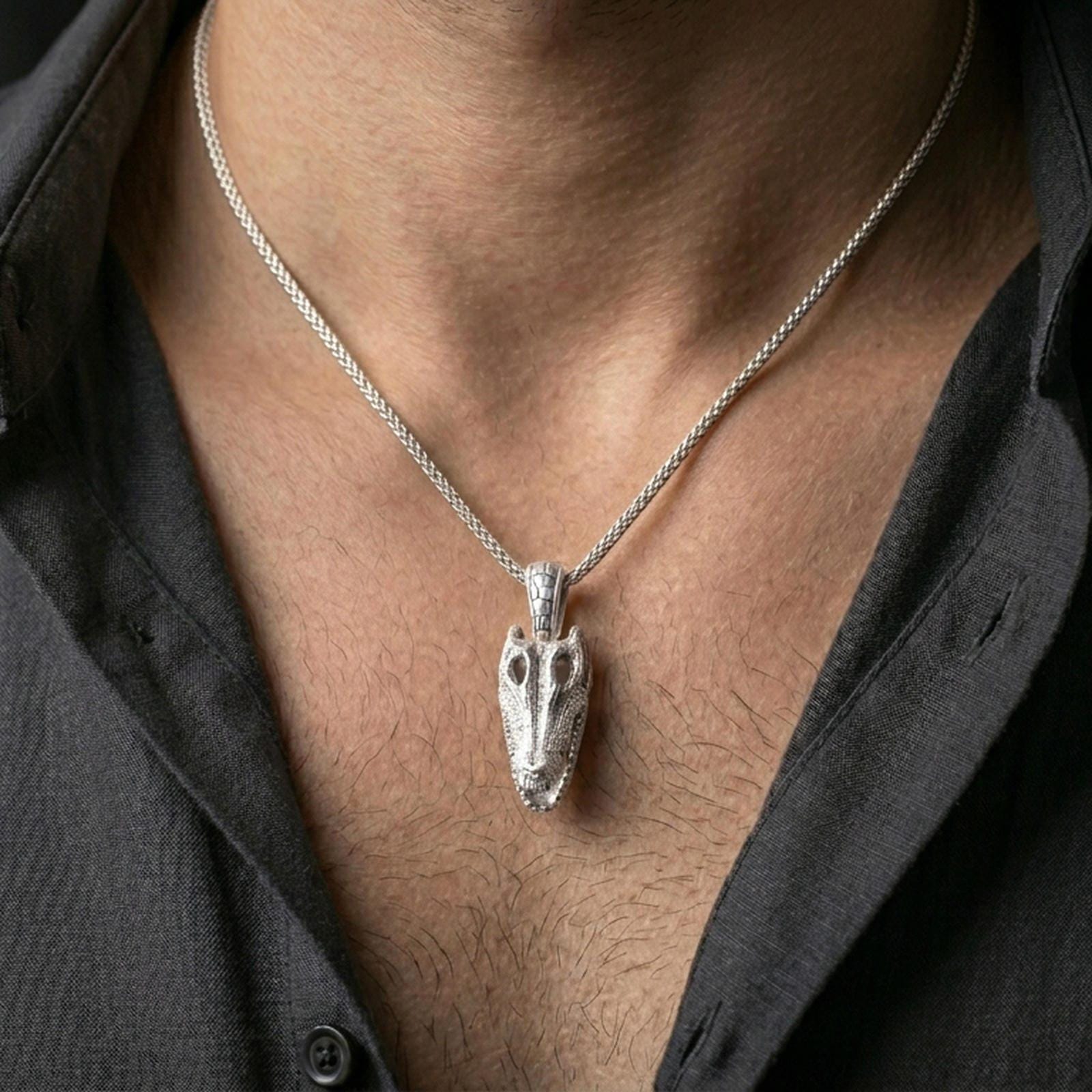 Polished silver gator skull necklace with sculpted skull structure and sharp tooth detail worn on the neck in a close lifestyle frame, highlighting the fierce reptile silhouette and realistic texture