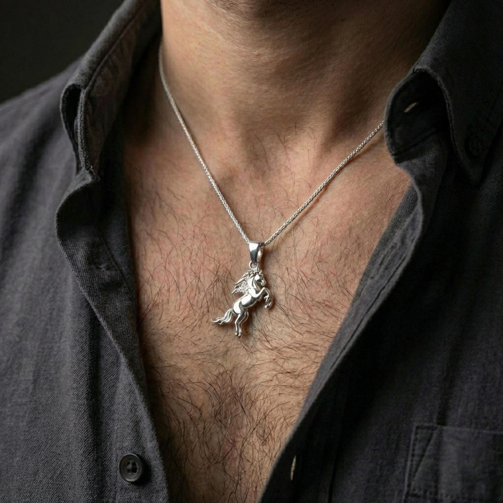 Polished silver horse necklace with flowing mane and rearing animal silhouette worn on the neck in a close lifestyle frame, highlighting the dynamic equine form and sculptural detail