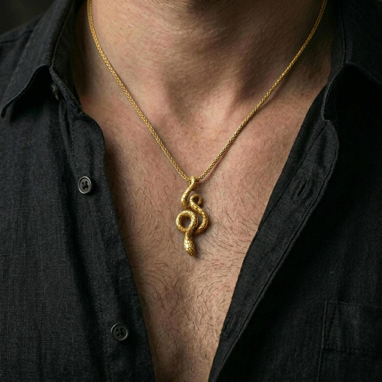 Gold plated snake pendant with flowing serpent body and symbolic design worn on the neck in a premium lifestyle composition with refined animal-inspired jewelry styling