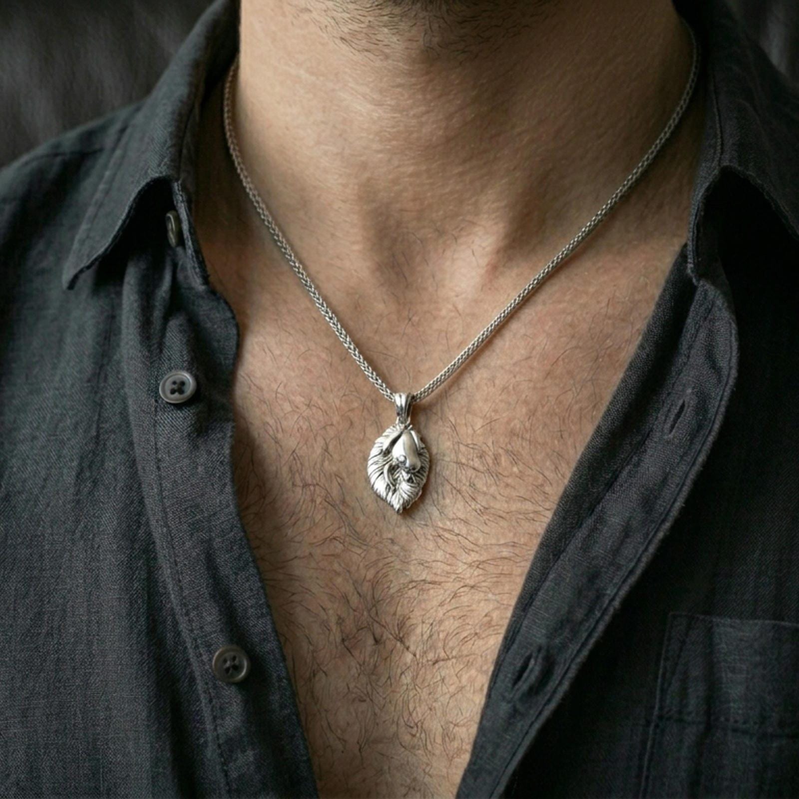 Polished silver frog necklace with sculpted amphibian relief and leaf-shaped base worn on the neck in a close lifestyle frame, highlighting the organic silhouette and refined craftsmanship