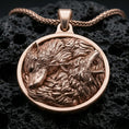 Load image into Gallery viewer, Rose gold plated wolfpack necklace with dual wolf composition, flowing fur texture, and elegant round medallion form resting on volcanic rock in an elegant close-up product presentation
