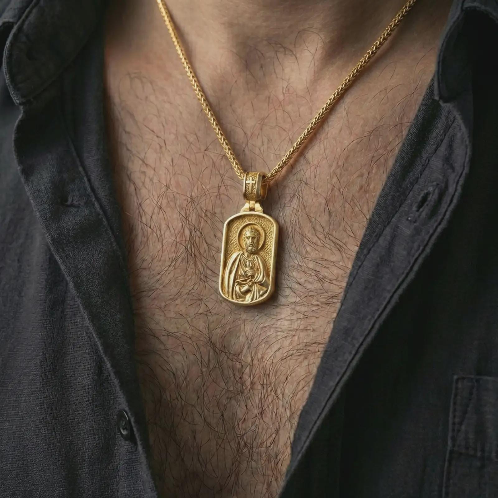 Gold plated Saint Peter dog tag pendant necklace worn on the neck, captured on a human model in a premium dark-toned lifestyle frame.