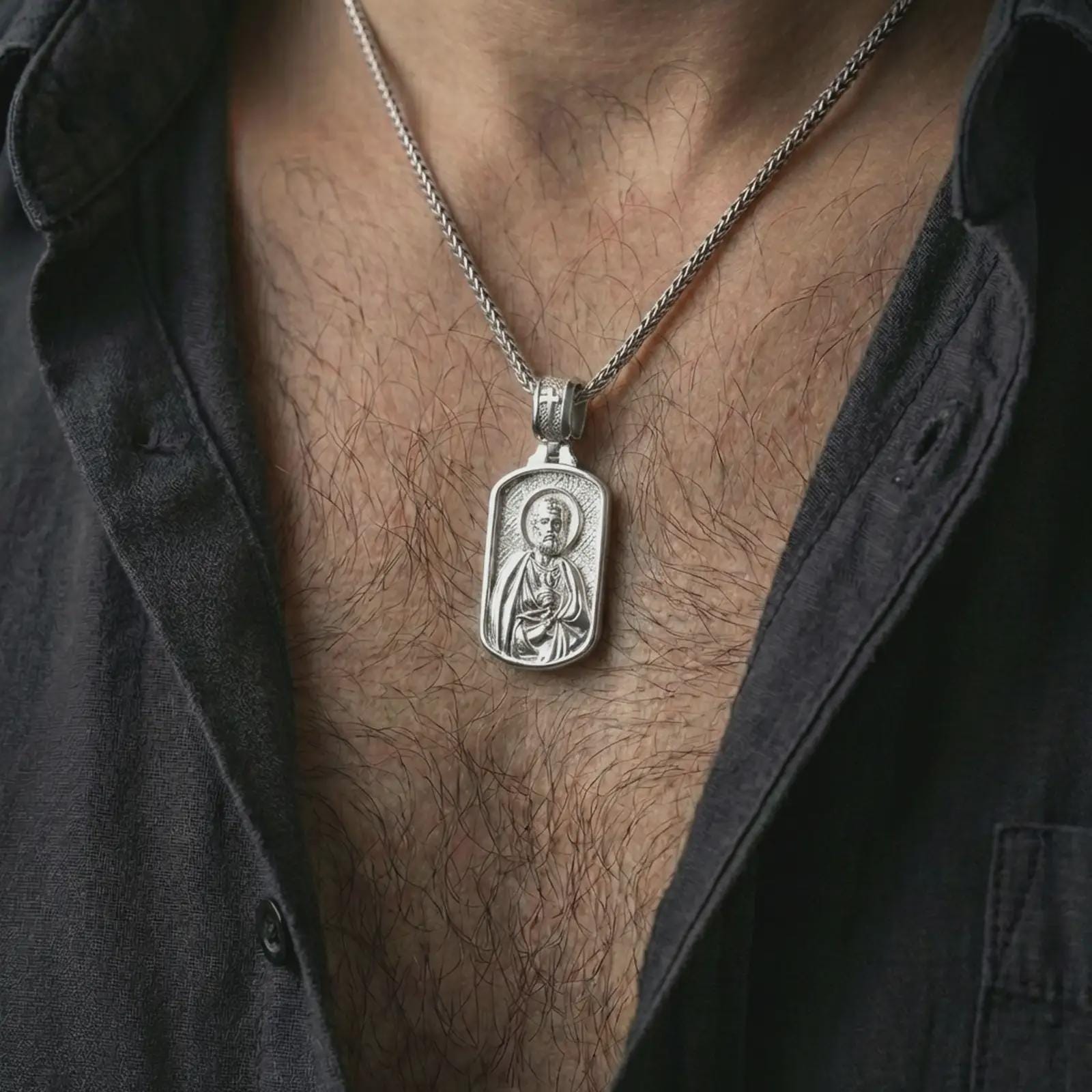 Polished silver Saint Peter dog tag pendant necklace worn on the neck, shown against the chest in a clean and elegant everyday wear composition.
