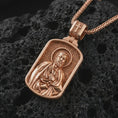 Load image into Gallery viewer, Rose gold plated Saint Peter dog tag pendant necklace on dark volcanic rock, photographed in a detailed premium studio macro view.
