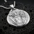 Load image into Gallery viewer, A polished 925 sterling silver Greek mythology coin pendant on volcanic rock featuring Perseus holding the Medusa head.
