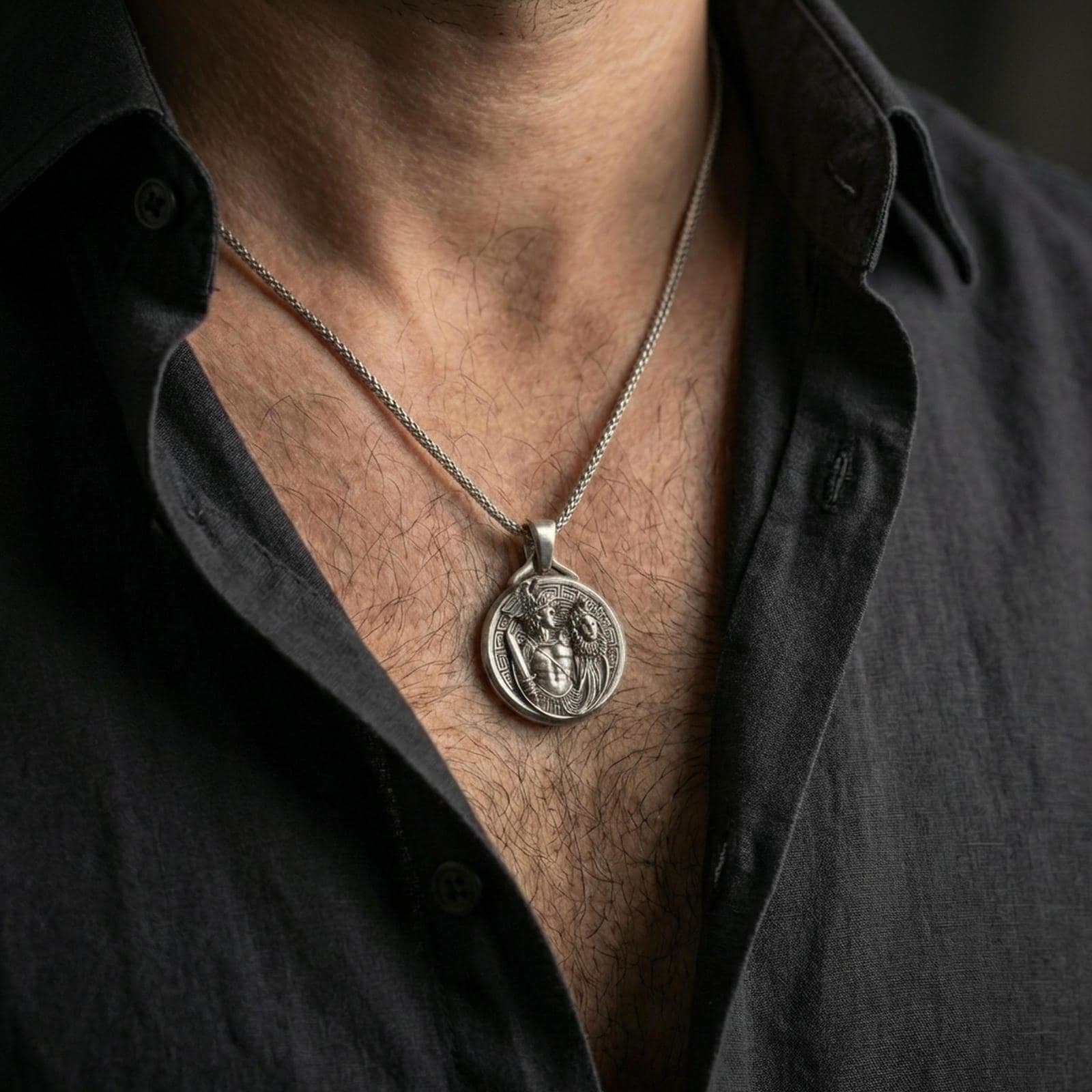 A 925 sterling silver Perseus and Medusa pendant worn on the neck, oxidized contrast highlighting the coin relief.