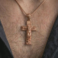Load image into Gallery viewer, Rose gold plated symbolic cross pendant worn on the neck, presented in a close-up lifestyle shot with a refined masculine aesthetic.
