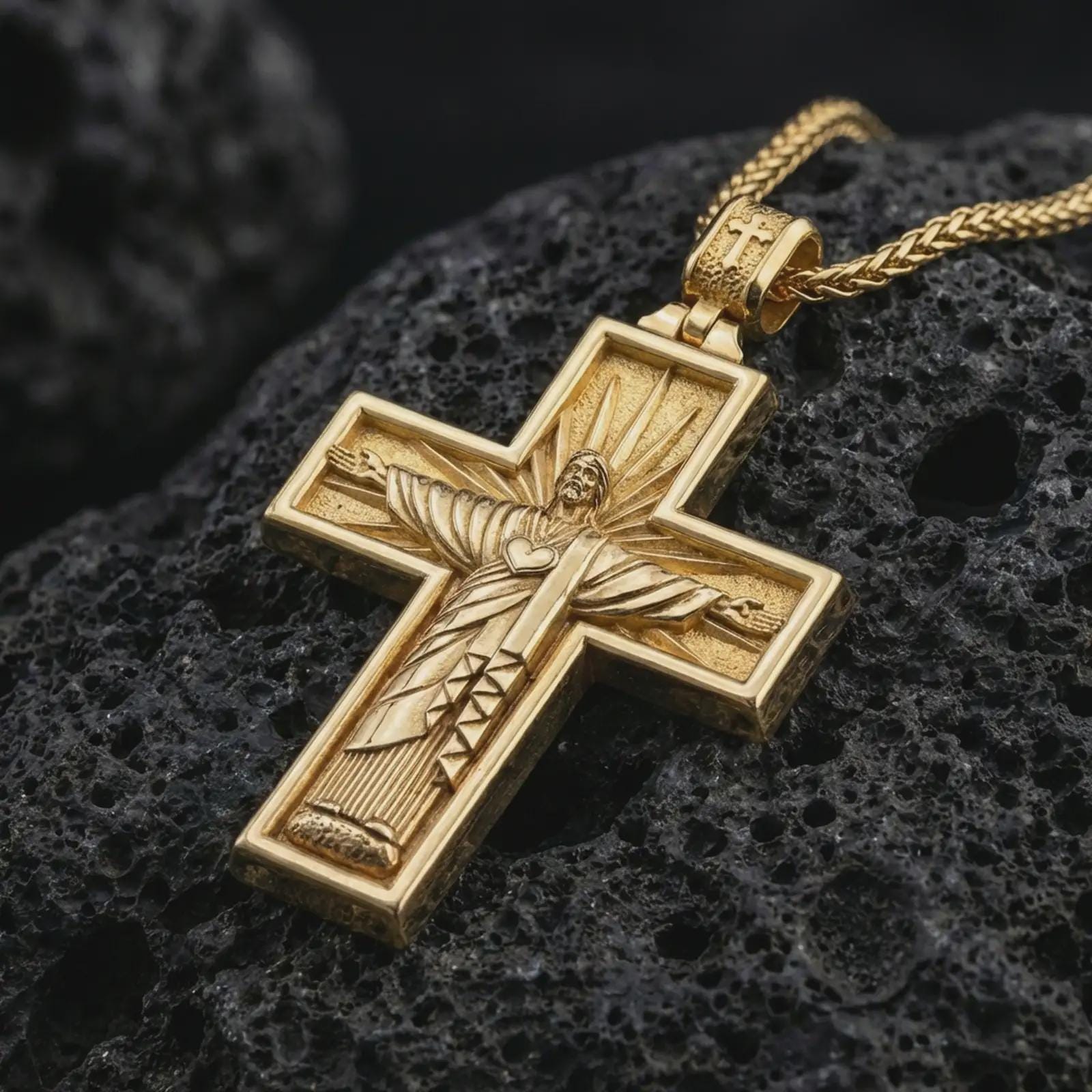 Gold plated Cristo Protetor cross pendant necklace presented on porous volcanic rock, highlighting the devotional cross form in a luxurious close-up jewelry image.