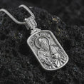 Load image into Gallery viewer, Polished silver Saint Paul dog tag pendant necklace displayed on black volcanic rock, shown in a refined macro product shot with detailed saint figure, sword, and engraved lettering.
