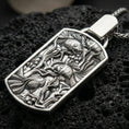 Load image into Gallery viewer, Polished silver aquarium necklace with sculpted fish details, flowing underwater plant motifs, and refined rectangular medallion design placed on textured volcanic rock in a premium studio product shot
