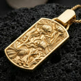 Load image into Gallery viewer, Gold plated sea life pendant with detailed fish relief, aquatic plant texture, and elegant rectangular underwater scene showcased on black volcanic rock in a refined macro jewelry image
