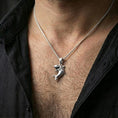 Load image into Gallery viewer, Polished silver shark necklace with sculpted swimming pose and detailed tooth relief worn on the neck in a close lifestyle frame, highlighting the playful predator silhouette and refined craftsmanship
