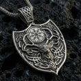 Load image into Gallery viewer, Oxidized Celtic deer pendant with stag head motif, antler silhouette, and shield-shaped Norse design displayed on dark volcanic rock in a close-up luxury jewelry composition
