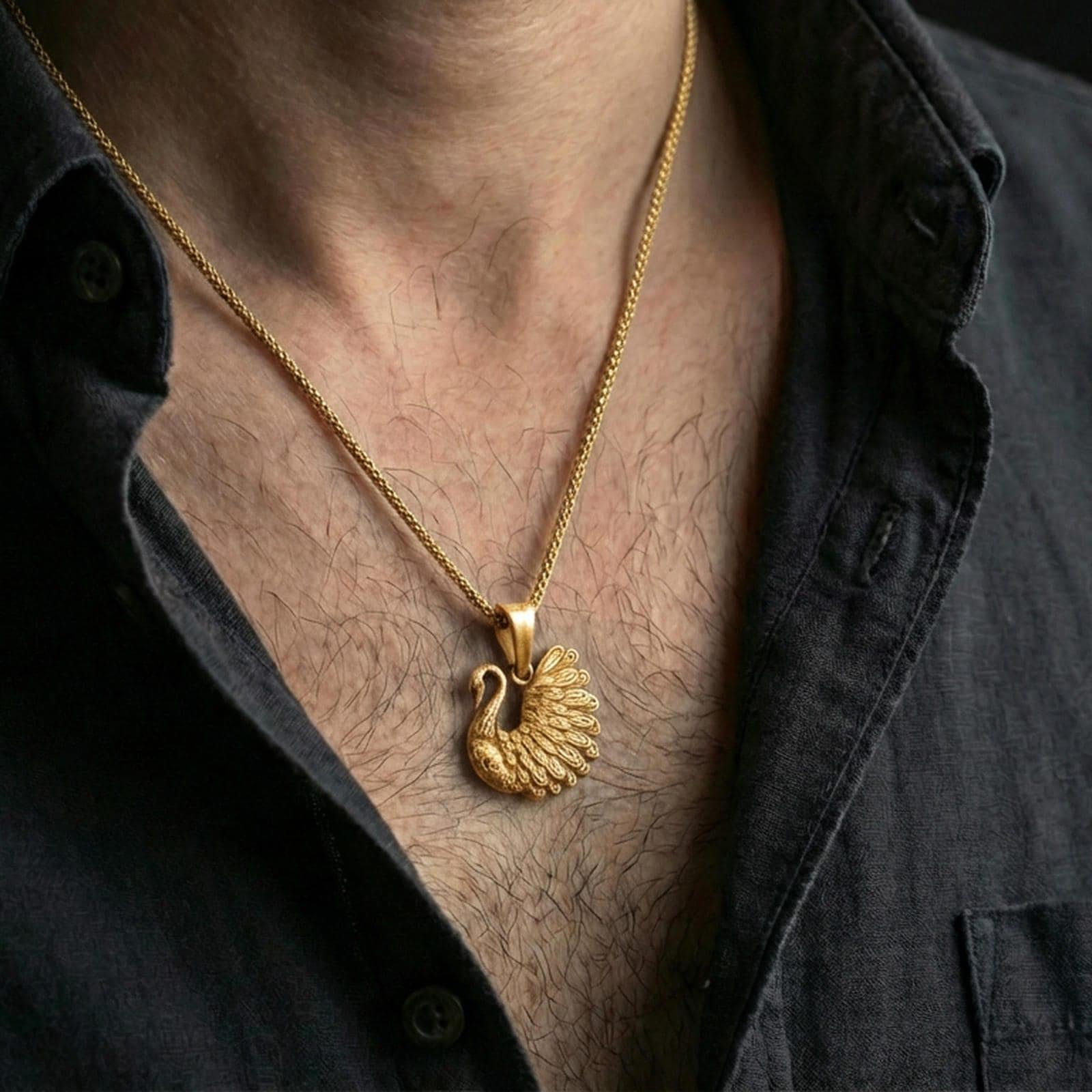 Gold plated swan pendant with ornate feather relief, curved neck silhouette, and elegant bird motif worn on the neck in a premium lifestyle composition with graceful animal-inspired jewelry styling