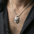 Load image into Gallery viewer, Polished silver geometric wolf necklace with angular low poly wolf head and sculpted faceted detailing worn on the neck in a close lifestyle frame, highlighting the contemporary animal silhouette and refined craftsmanship
