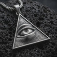 Load image into Gallery viewer, Sterling silver all-seeing eye pendant necklace with an oxidized finish resting on textured volcanic rock, captured in a close-up premium studio composition.
